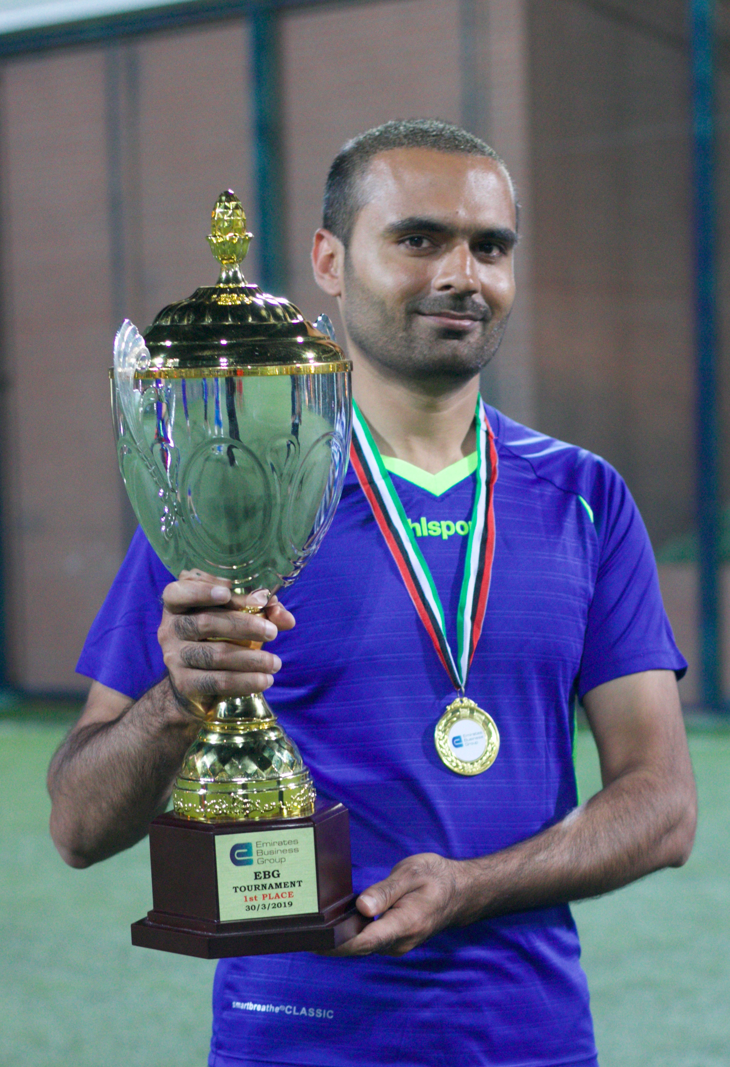 A Falcon Sports UAE player lifting a tournament trophy in Abu Dhabi